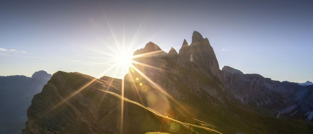 The sun setting behind a mountain.