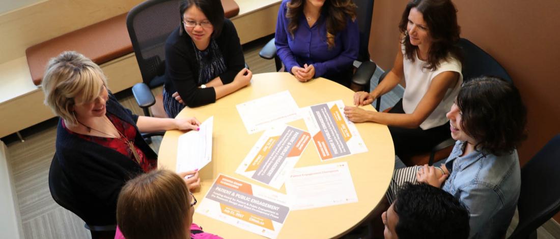 Group of staff sitting at a round table.