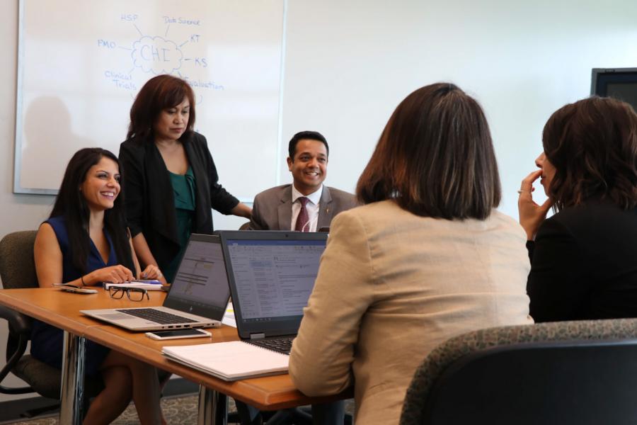 Staff seated around a table.