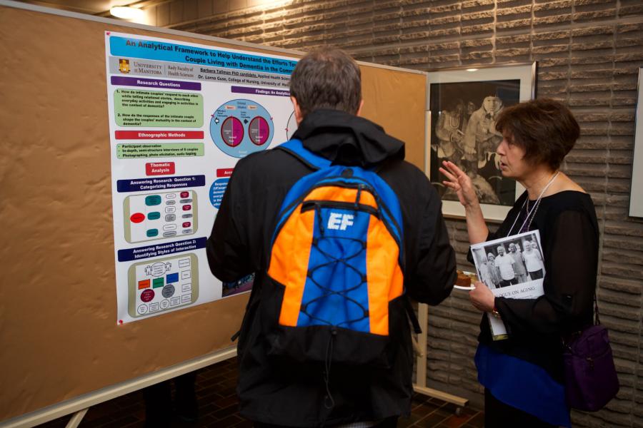 A graduate student presents her aging related research during the poster session at the Spring Research Symposium.
