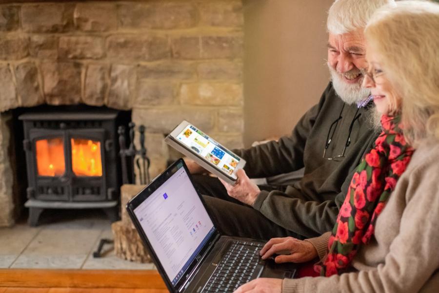 An older couple look at online information on a tablet and ipad.