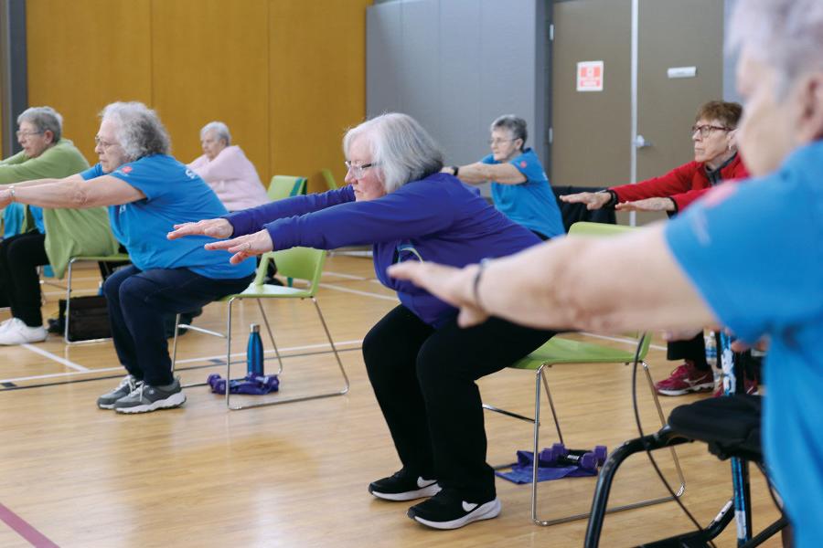 Seniors doing stretches in a group exercise class.