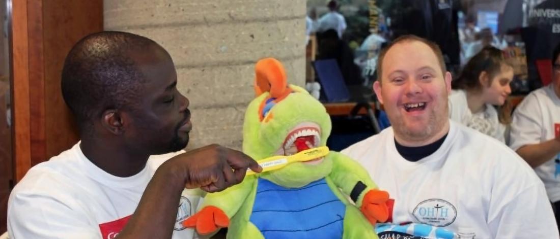 Two participants at the annual Sharing Smiles Day sit together at a table.