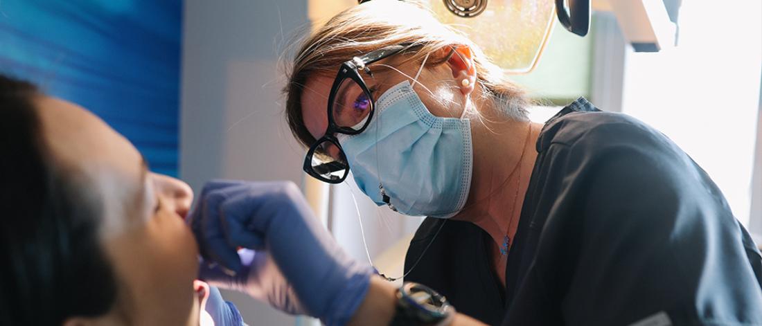 Patient with doctors at the dentist office.
