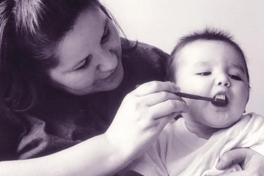 Mother brushes her baby's teeth