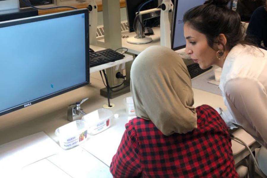 Two people seen from the back, working at a table in a student lab.