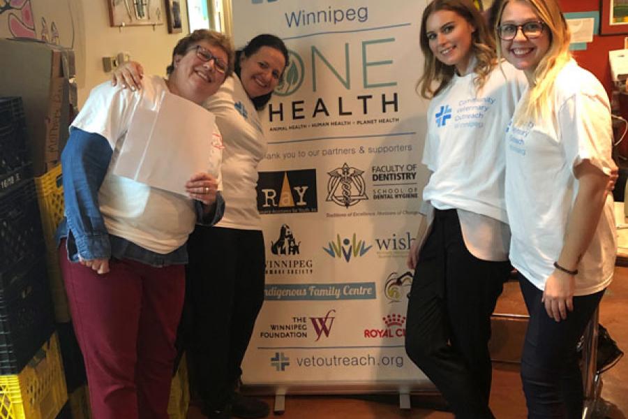 A group of people posing in front of a banner sign.