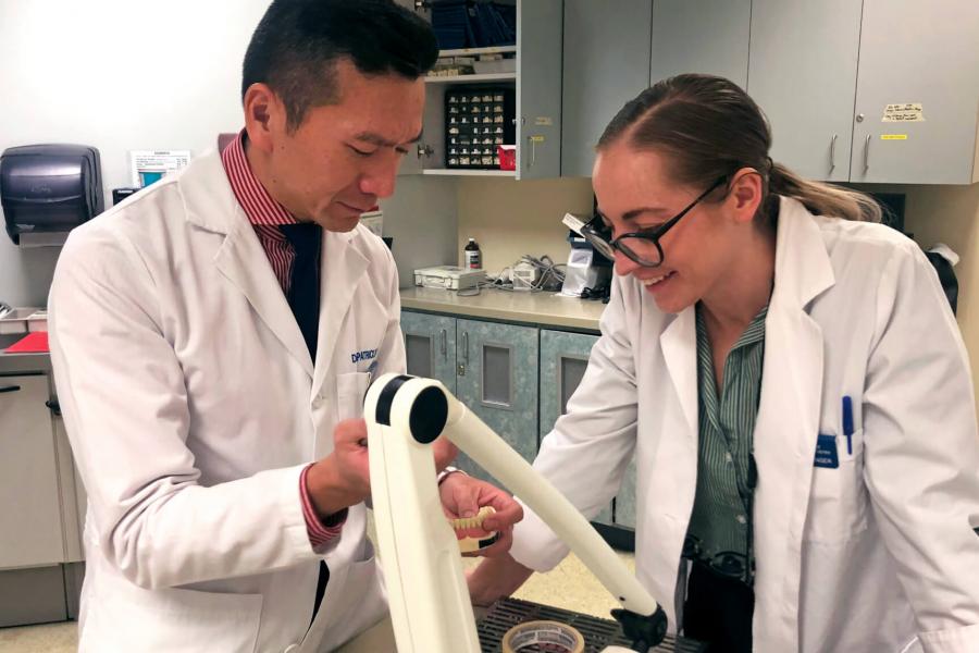 A prosthodontic dentist works with a student. 