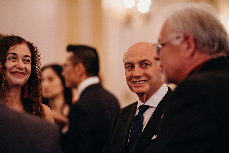 a group of men and a woman talking at an event.