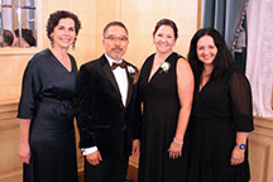 Four people in formal wear pose for photo. 