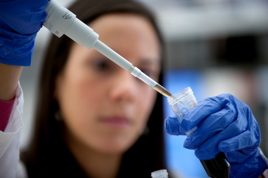 Closeup of a pipette being used to extract liquid from a tube.