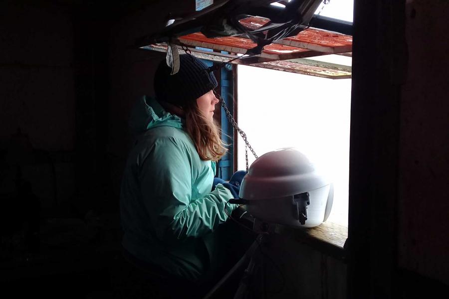 Researcher Emma Ausen observing wildlife in Churchill out a window.