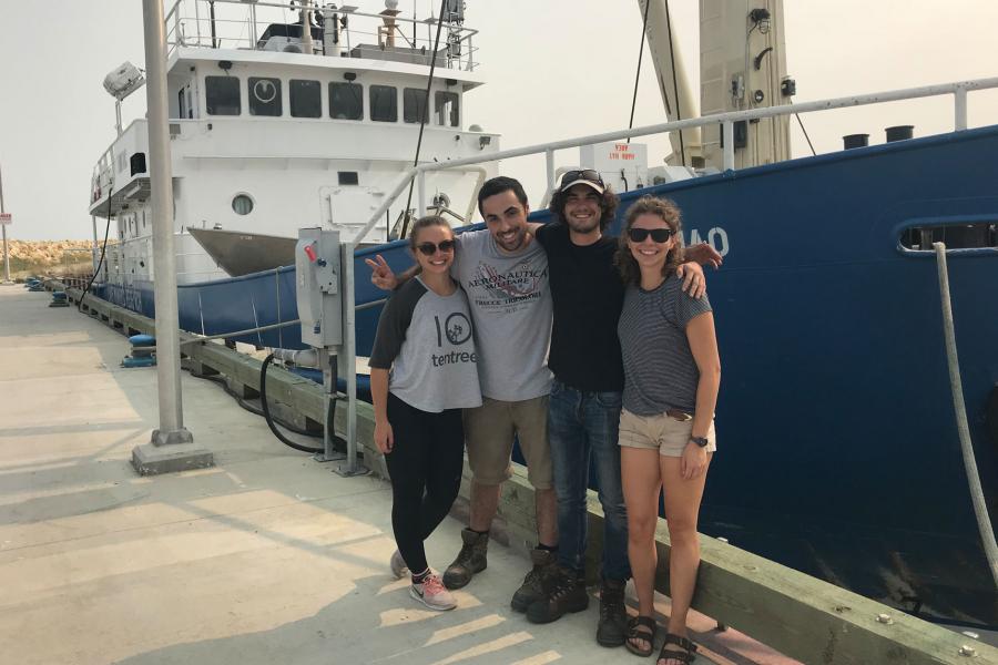 Four researchers posing in front of the MV Namao.