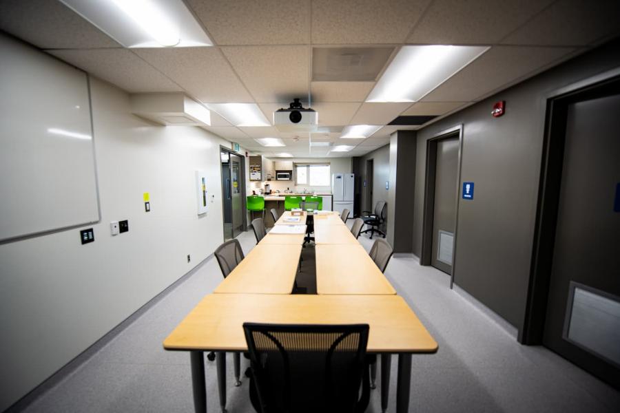 Conference room with long table and kitchen in the back