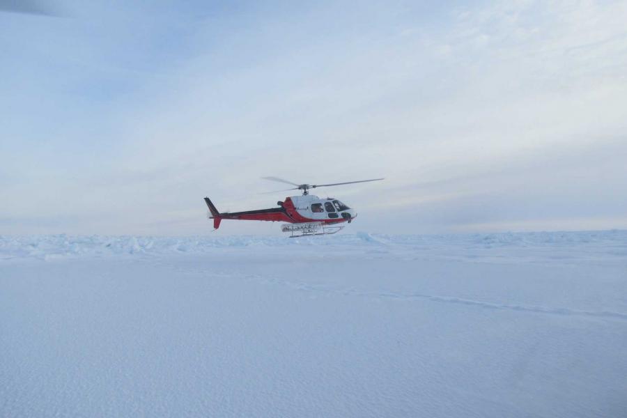 a helicopter taking off from arctic sea ice.