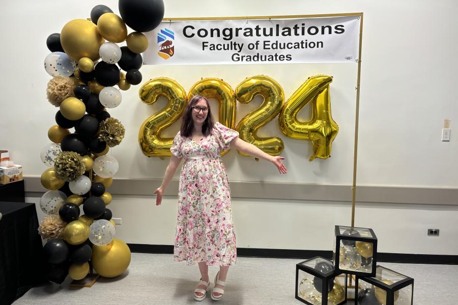 woman posing for photo, smiling, behind her 2024 gold balloons 