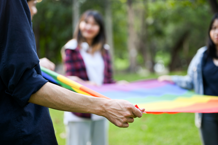 students holding rainbow flag flat
