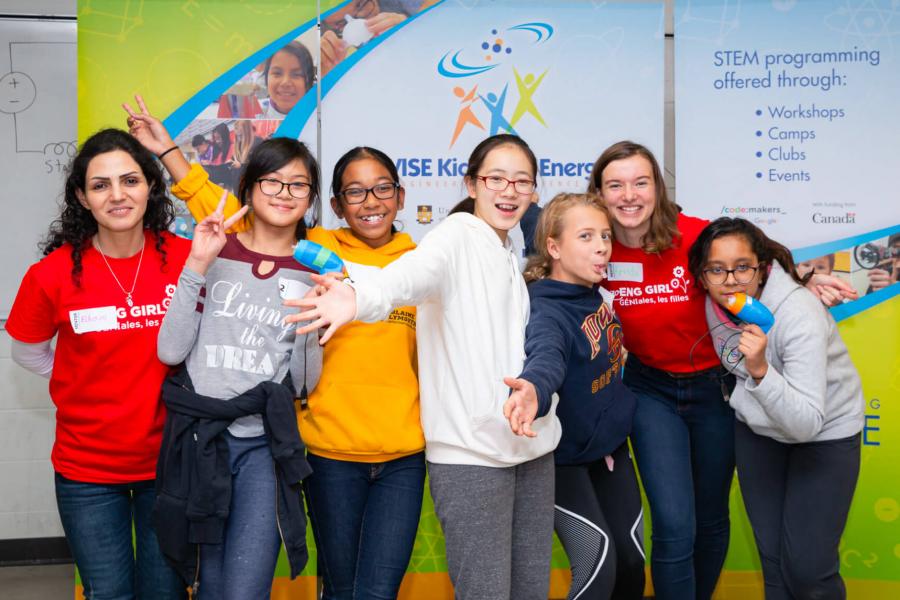 A group of young women pose for a photo with their leader at the Assistive Technology Build-A-Thon. 