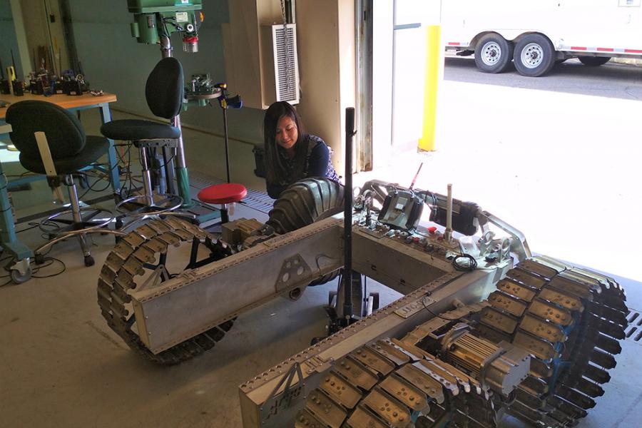 A mechanical engineering student works on a robotic vehicle. 