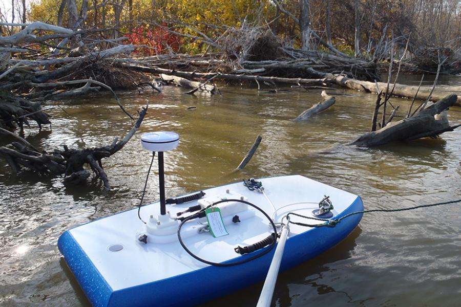 Research equipment sits floating in a wooded lagoon. 