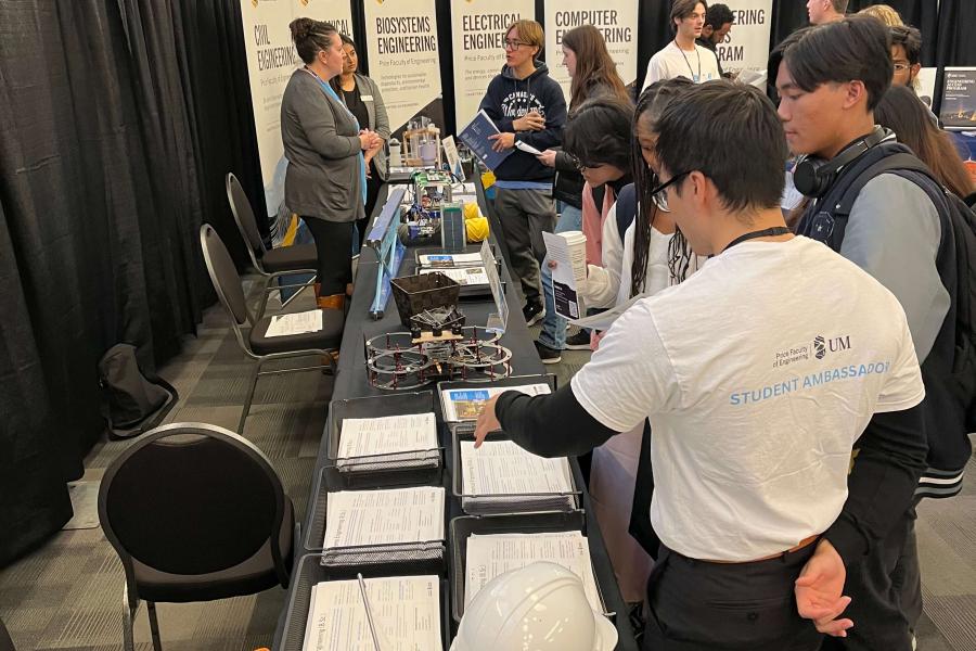 students at event asking questions at a table