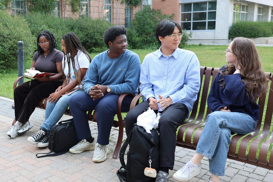 students talking on a bench outside