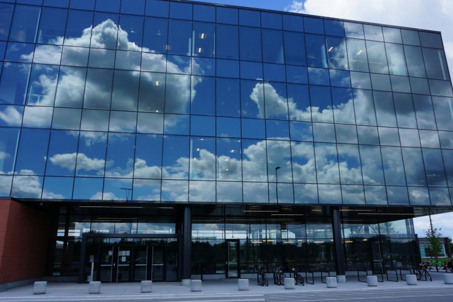 Partnerships and Innovation building's mirrored windows reflecting clouds