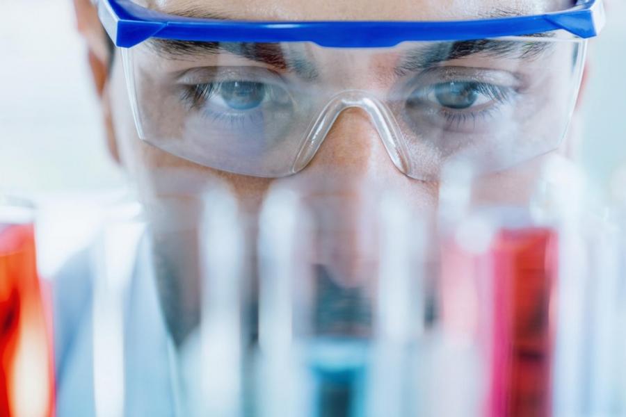 Close up of person in lab in safety goggles.