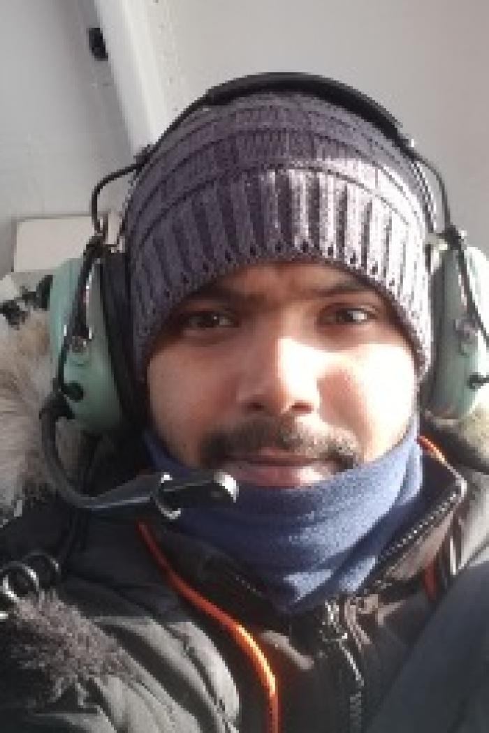 Kaushik Gupta wearing warm outerwear and helicopter headphones