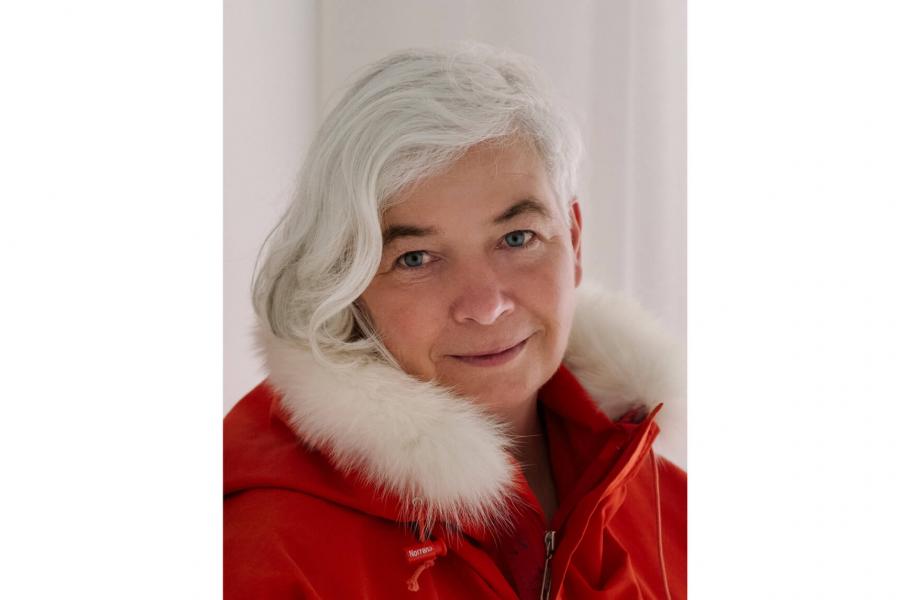 A portrait of Dorthe Dahl-Jensen wearing a bright red jacket with a while fur collar.