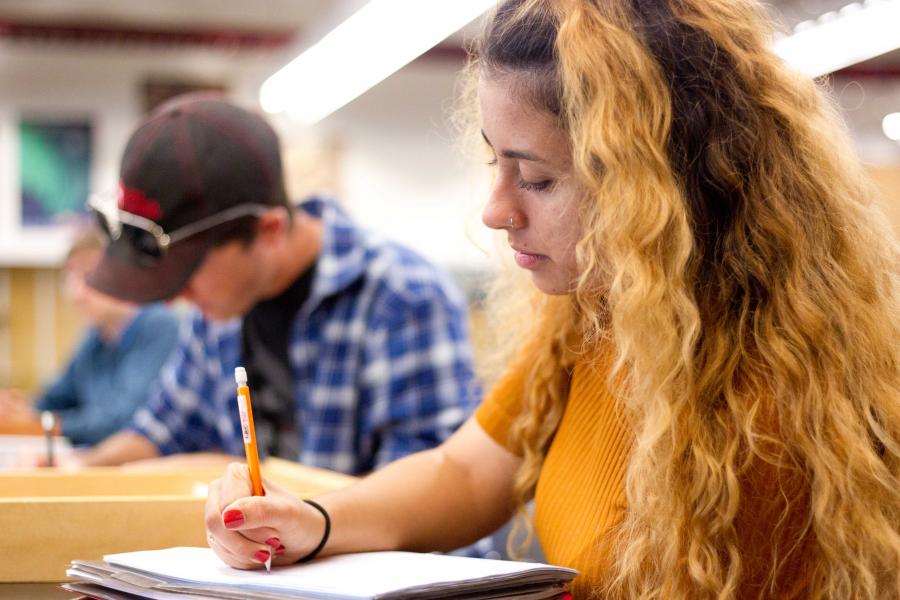 student writing notes in classroom