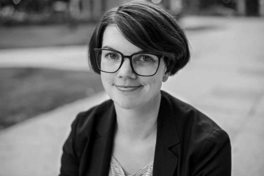 Doctor nicole wilson smiling at camera outdoors black and white photo.