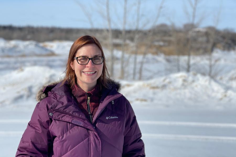 Lisa ford standing outside in a purple parka and sunglasses.