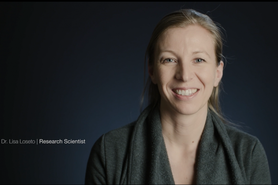 Doctor lisa loseto posing against a dark background smiling at camera.