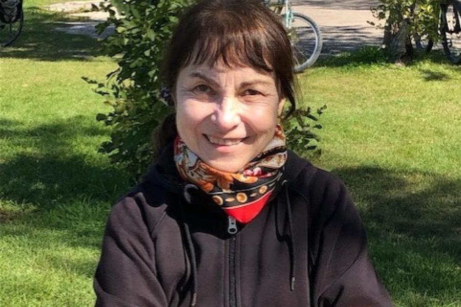 Elena sokolova standing outside with her arms crossed and smiling at camera.