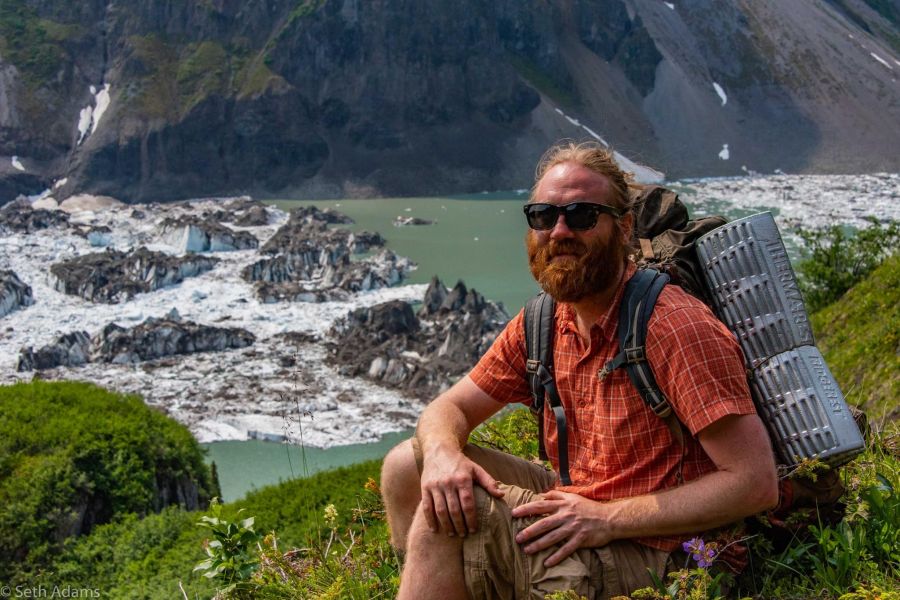 Dr. eric collins sitting outside by some rocks.