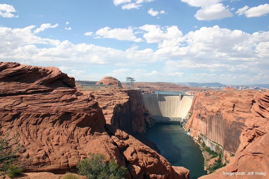 A canyon with a dam and a river flowing from it.