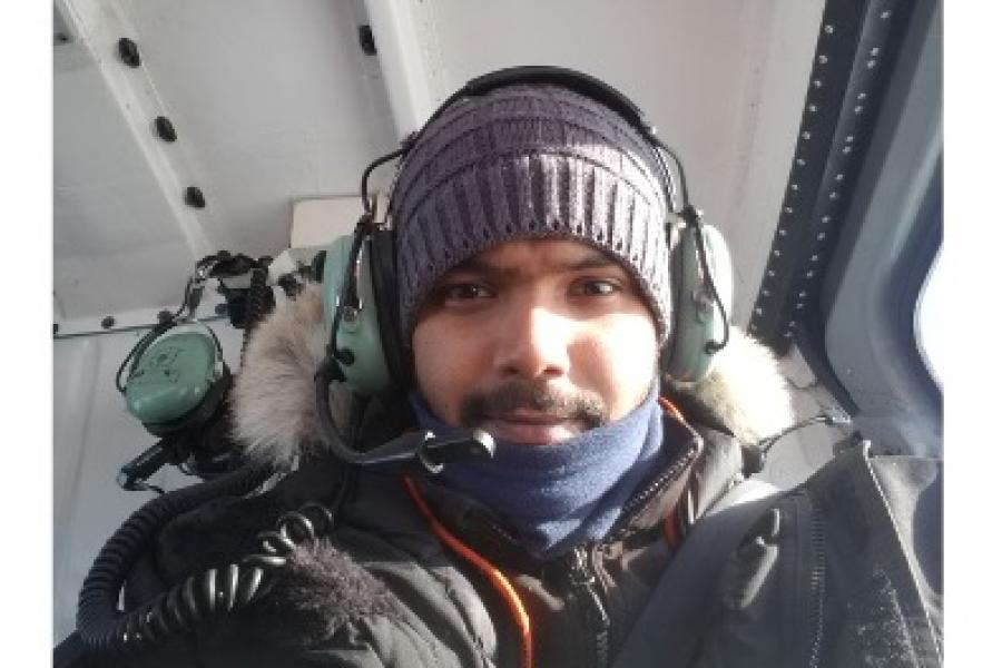 Kaushik gupta wearing warm outerwear and helicopter headphones.