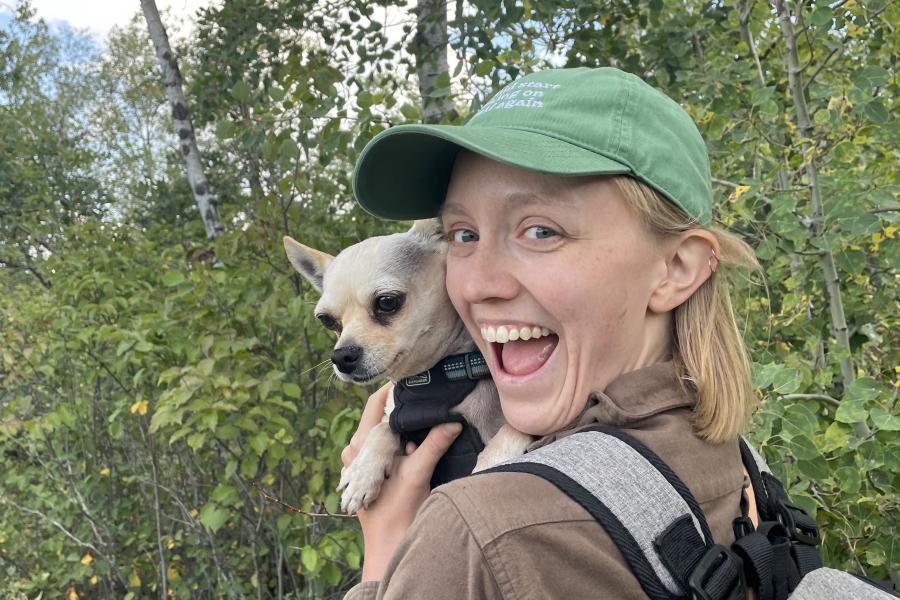 Lila holding a dog while standing outside