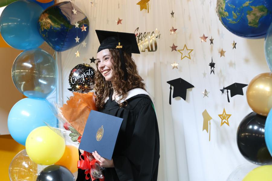 Graduate with parchment in photo booth