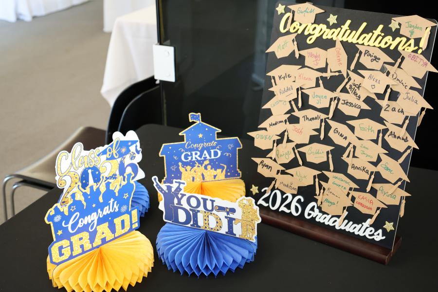 Graduate names on grad caps and blue and yellow decorations
