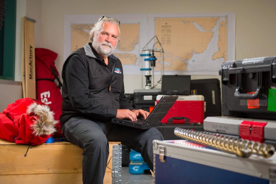 Professor David G. Barber sits in an office space using a laptop.