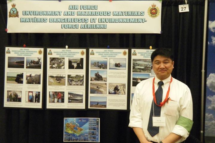 Alan Ng stands in front of his Air Force - Environment and Hazardous Materials booth.