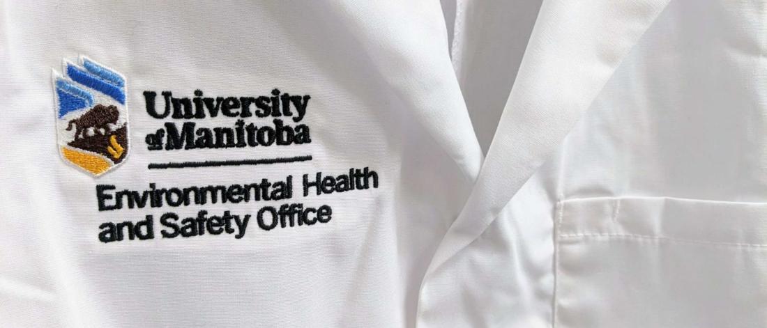 University of Manitoba crest with the words Environmental Health and Safety stitched onto a lab coat. 