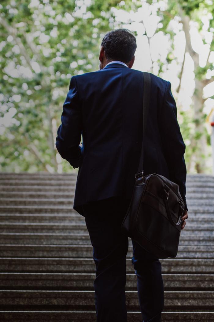 Business leader walking up steps.
