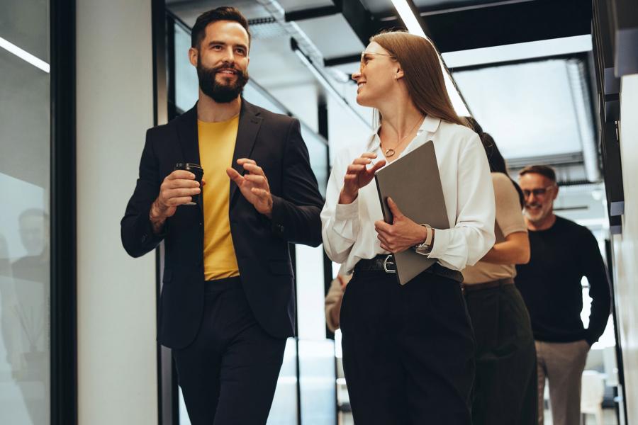 Business professionals walking in modern office and discussing ideas.