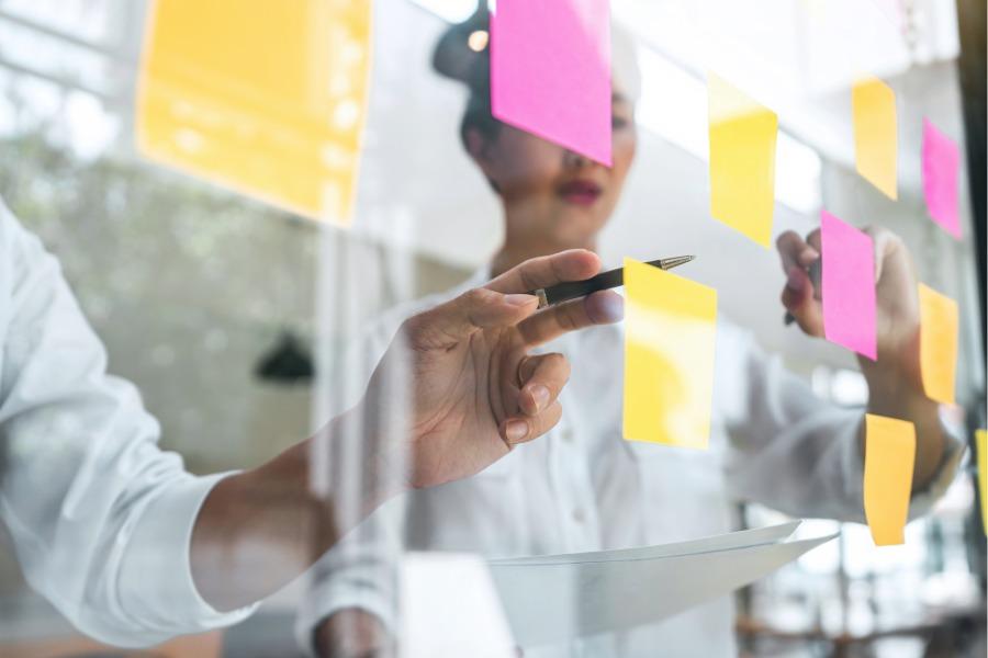 Two people using post it notes to develop strategy