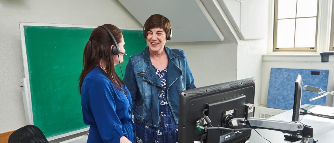 Two social work researchers stand at a desk together. 