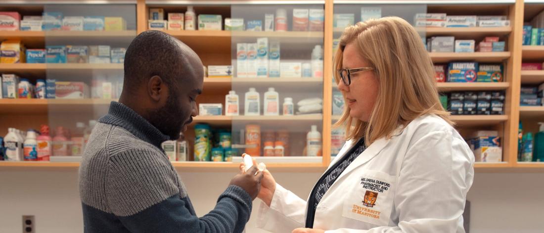 A pharmacist looks over a prescription with a customer.