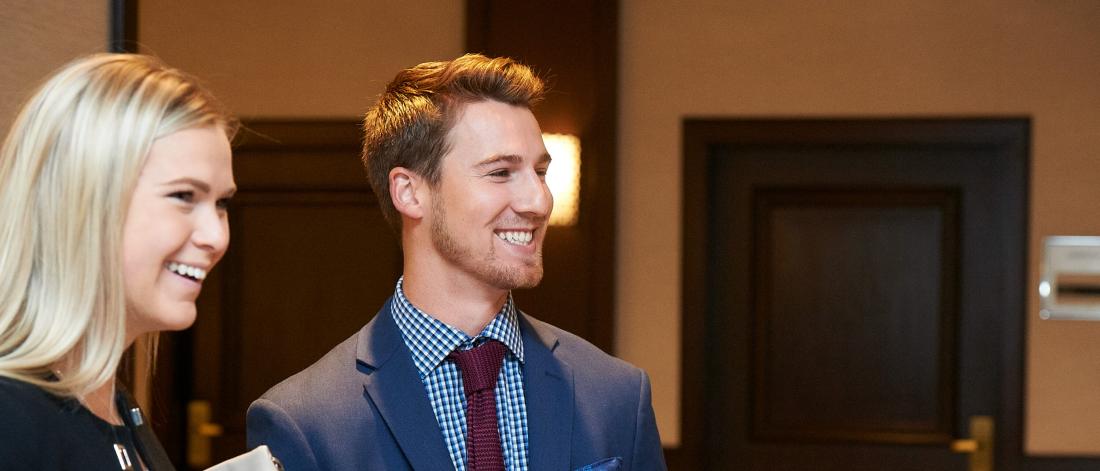 Two Asper School of Business students stand together at an event.